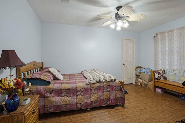 bedroom featuring hardwood / wood-style flooring, ceiling fan, and a textured ceiling