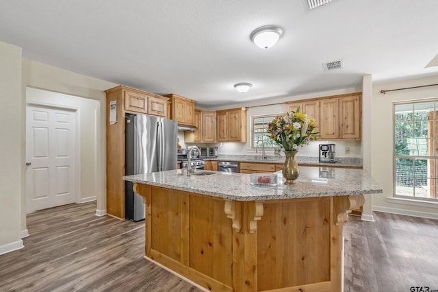 3466 County Road 4305, Larue, TX 75770 - kitchen with stainless steel appliances, wood finished floors, a sink, baseboards, and plenty of natural light