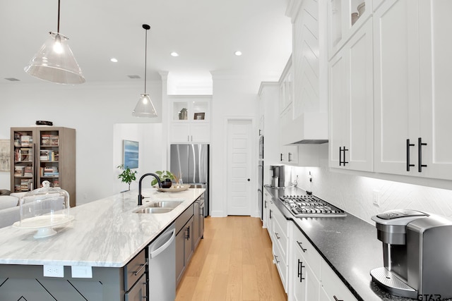 kitchen featuring sink, hanging light fixtures, appliances with stainless steel finishes, a large island, and white cabinets