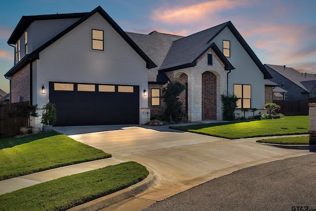 view of front of property featuring a garage and a lawn