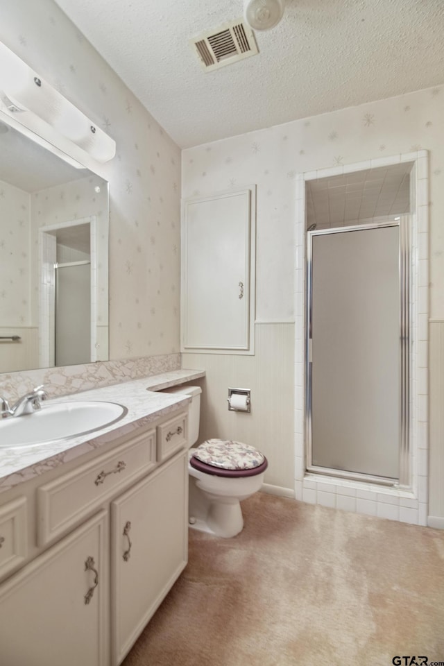 2742 Lisa Ln, Tyler, TX 75701 - bathroom featuring wallpapered walls, vanity, a stall shower, wainscoting, and a textured ceiling