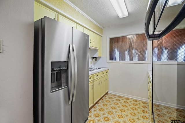 2742 Lisa Ln, Tyler, TX 75701 - kitchen with stainless steel refrigerator with ice dispenser, light countertops, cream cabinets, a textured ceiling, and light floors