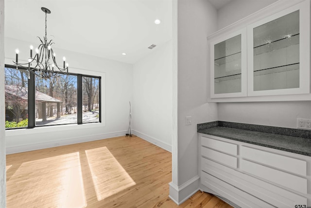 unfurnished dining area featuring a chandelier, recessed lighting, visible vents, baseboards, and light wood finished floors