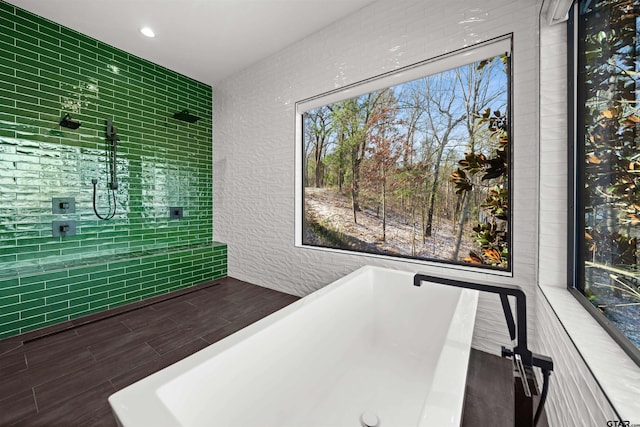 full bath featuring a freestanding bath, a textured wall, recessed lighting, and wood tiled floor