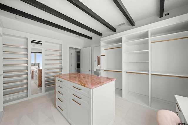 spacious closet featuring beam ceiling and visible vents