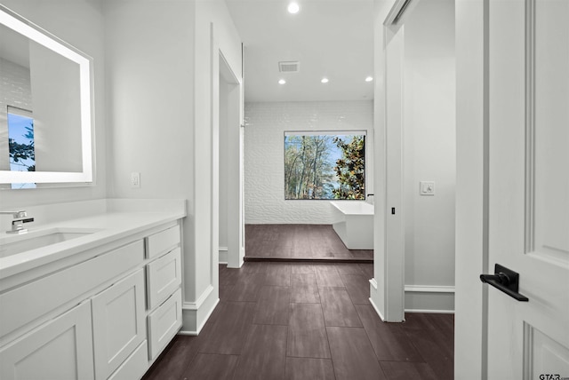 full bath featuring recessed lighting, wood finish floors, vanity, visible vents, and a freestanding bath