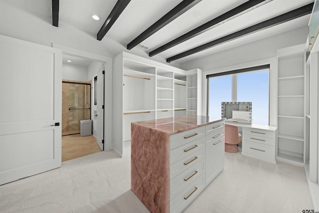 spacious closet with beam ceiling and light carpet