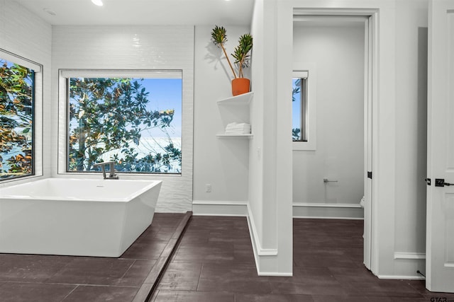 bathroom featuring recessed lighting, a soaking tub, toilet, and baseboards