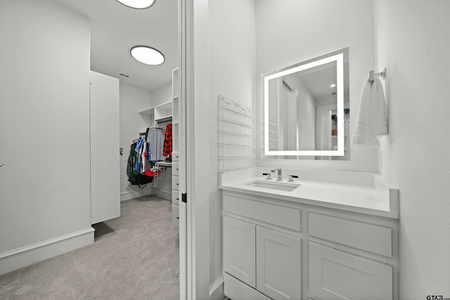 bathroom featuring a walk in closet and vanity