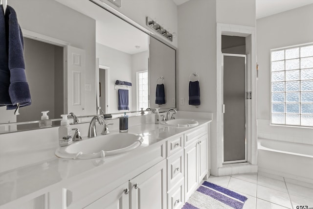 bathroom featuring tile patterned flooring, a shower stall, double vanity, and a sink