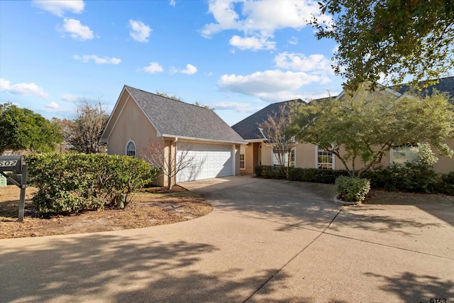 view of front of home featuring an attached garage, driveway, and stucco siding