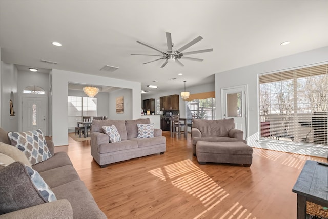 living area with recessed lighting, visible vents, and light wood finished floors