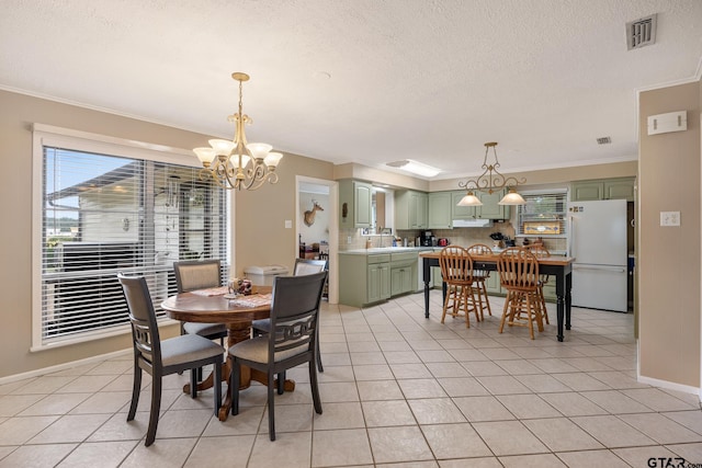 311 E Amherst St, Tyler, TX 75703 - dining space with a chandelier, a textured ceiling, ornamental molding, light tile patterned flooring, and baseboards