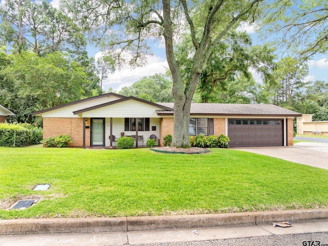 311 E Amherst St, Tyler, TX 75703 - view of front of property featuring brick siding, a garage, driveway, and a front yard