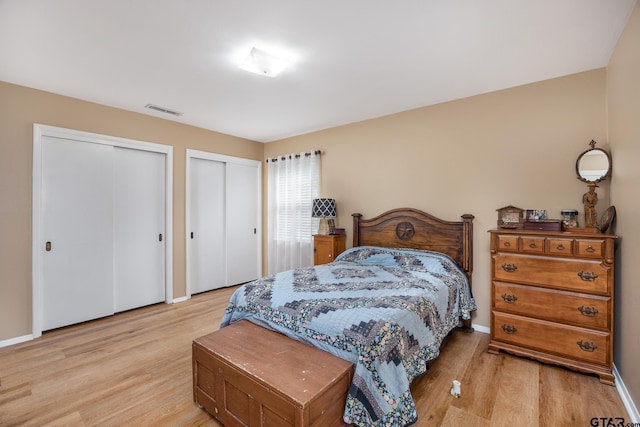 311 E Amherst St, Tyler, TX 75703 - bedroom with two closets, light wood-style floors, and baseboards