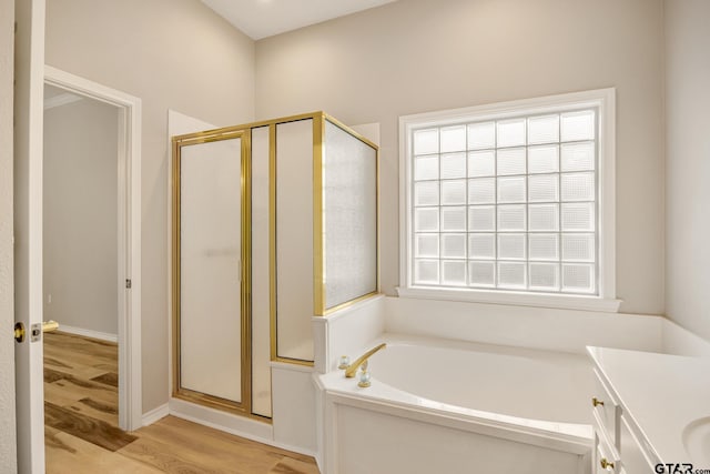 bathroom with hardwood / wood-style flooring, vanity, and separate shower and tub