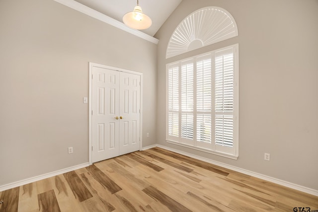 unfurnished room with a wealth of natural light, lofted ceiling, and light hardwood / wood-style flooring