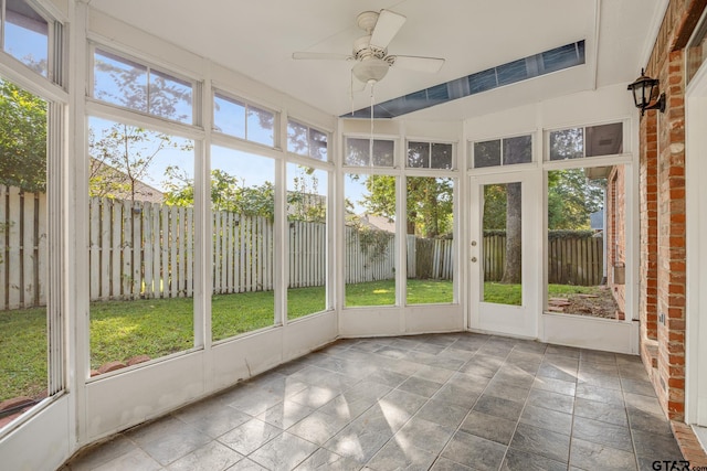 unfurnished sunroom featuring a wealth of natural light and ceiling fan