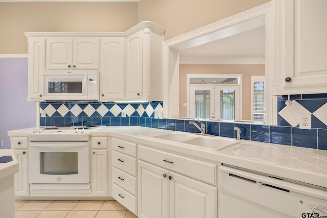 kitchen with white cabinets, tile countertops, sink, and white appliances