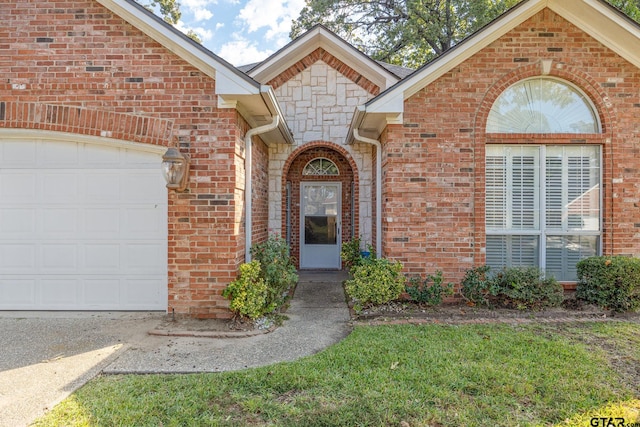 doorway to property with a lawn and a garage