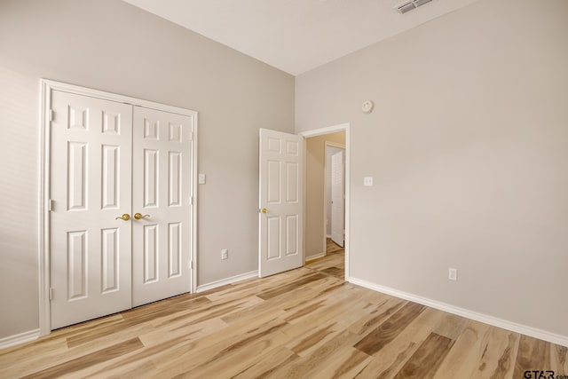 unfurnished bedroom with a closet and light wood-type flooring