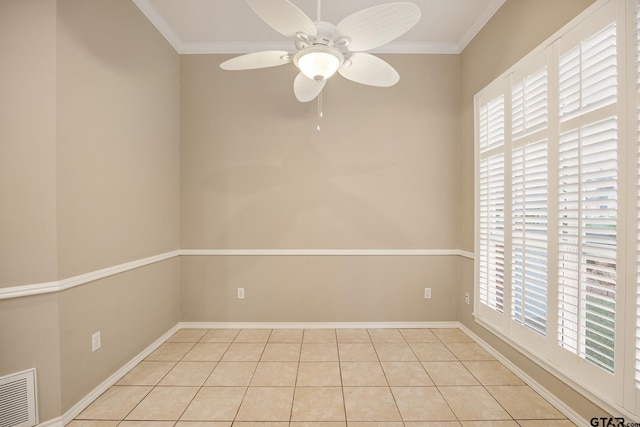 empty room with ceiling fan, a healthy amount of sunlight, light tile patterned floors, and ornamental molding