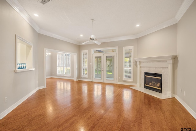 unfurnished living room with a fireplace, crown molding, ceiling fan, and light hardwood / wood-style flooring