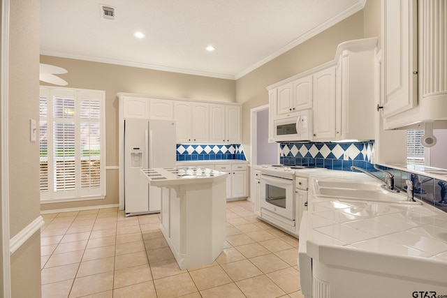 kitchen featuring white cabinetry, white appliances, sink, and a center island