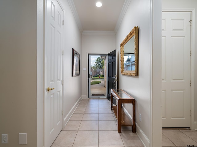 entryway with ornamental molding and light tile patterned flooring