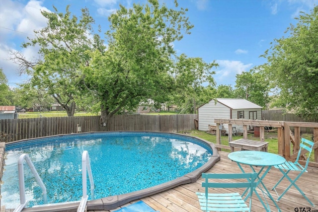 view of swimming pool featuring a storage shed and a wooden deck