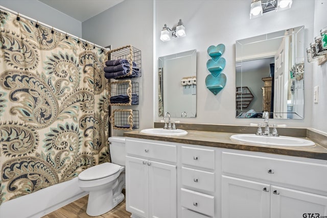 full bathroom with wood-type flooring, shower / bath combination with curtain, toilet, and vanity