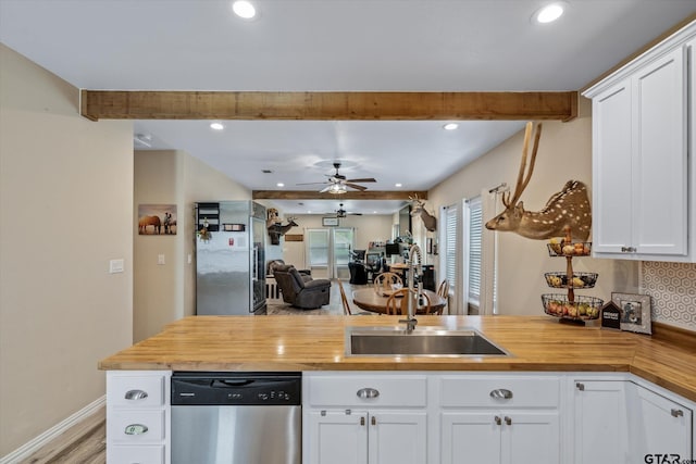 kitchen featuring white cabinetry, sink, wooden counters, ceiling fan, and dishwasher