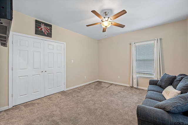 living area featuring light carpet and ceiling fan