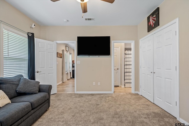 carpeted living room with ceiling fan