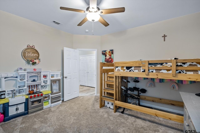 carpeted bedroom with ceiling fan and sink