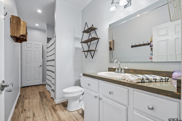 bathroom featuring toilet, vanity, a shower with shower curtain, and hardwood / wood-style flooring