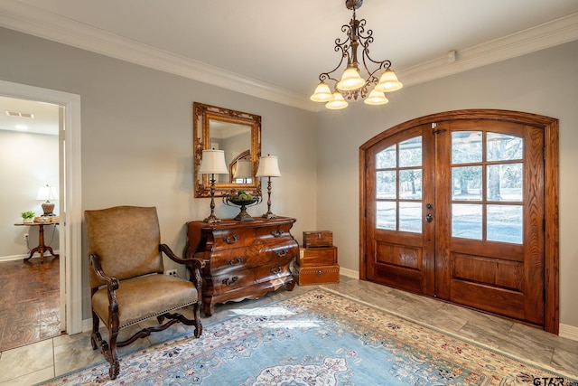 tiled entrance foyer featuring french doors, ornamental molding, and a chandelier