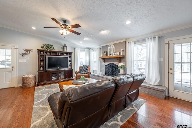408 Cumberland Rd, Tyler, TX 75703 - living area featuring crown molding, a brick fireplace, wood finished floors, a ceiling fan, and a textured ceiling
