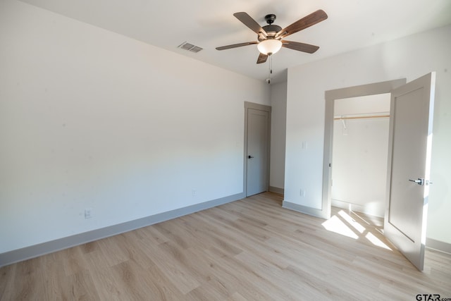 unfurnished bedroom with light hardwood / wood-style floors, ceiling fan, and a closet