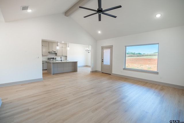 unfurnished living room with high vaulted ceiling, light wood-type flooring, and beam ceiling