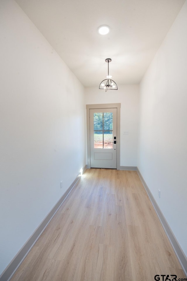 entryway with light hardwood / wood-style flooring and a chandelier