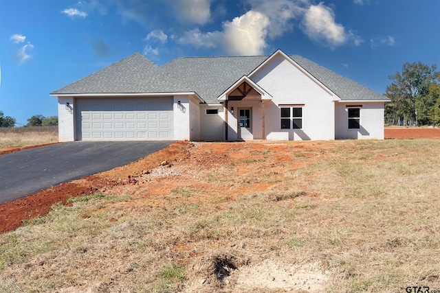 ranch-style house featuring a garage and a front yard