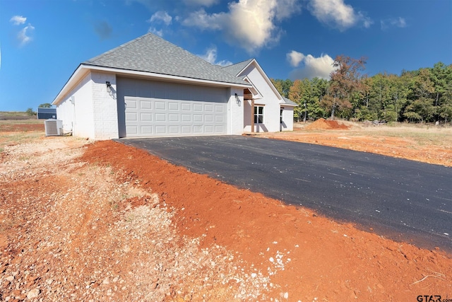 view of side of home featuring a garage and cooling unit