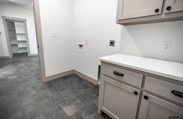 clothes washing area featuring hookup for an electric dryer, washer hookup, and cabinets