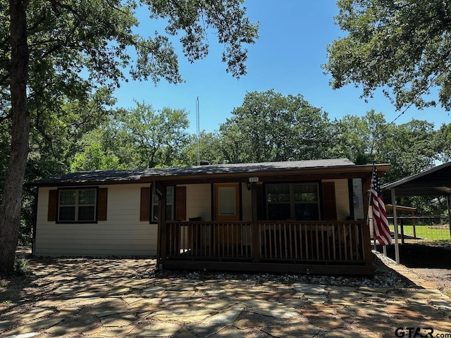 single story home featuring covered porch and a carport