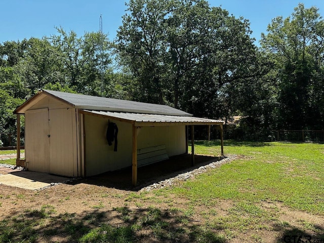 view of outdoor structure with a yard and a carport