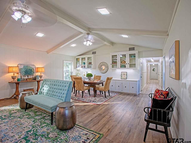 living room with lofted ceiling with beams, light hardwood / wood-style floors, and ceiling fan