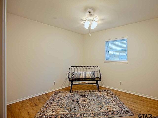 living area featuring hardwood / wood-style floors and ceiling fan