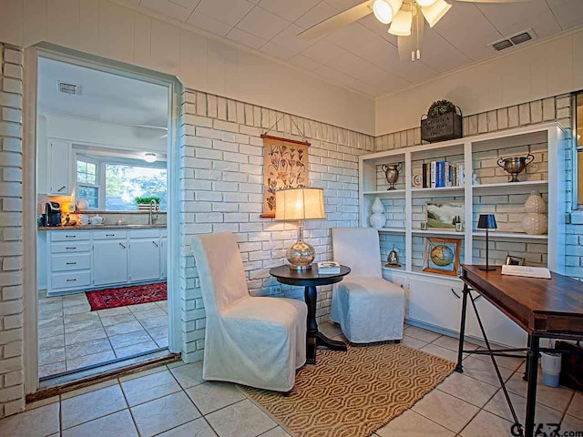 sitting room featuring ceiling fan, sink, and light tile patterned floors