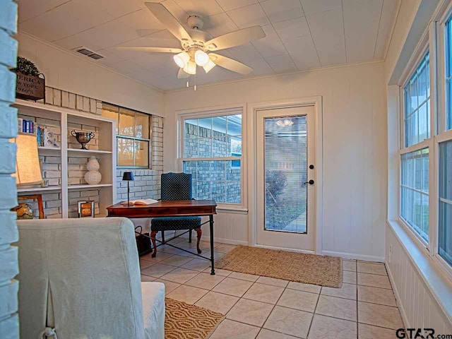 tiled home office with built in features, ceiling fan, and crown molding